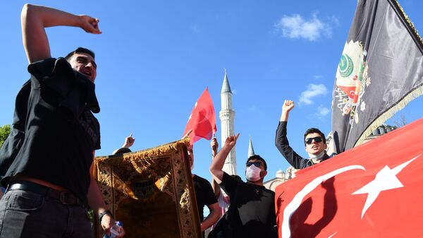 Местные жители с турецкими флагами у собора Святой Софии в Стамбуле, который снова снова стал мечетью