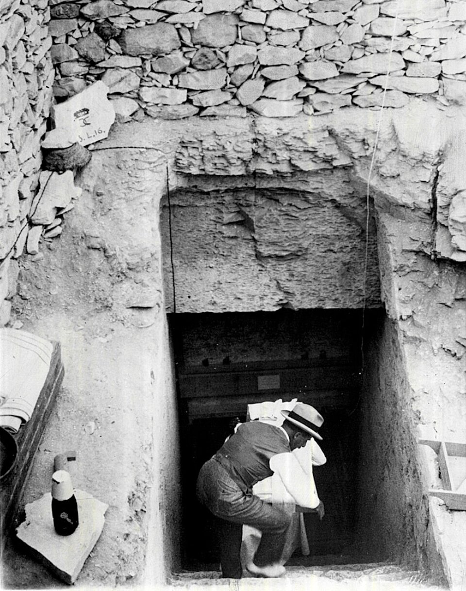 Дэвис, сотрудник Говарда Картера помогает выносить предметы из гробницы Тутанхамона.1923