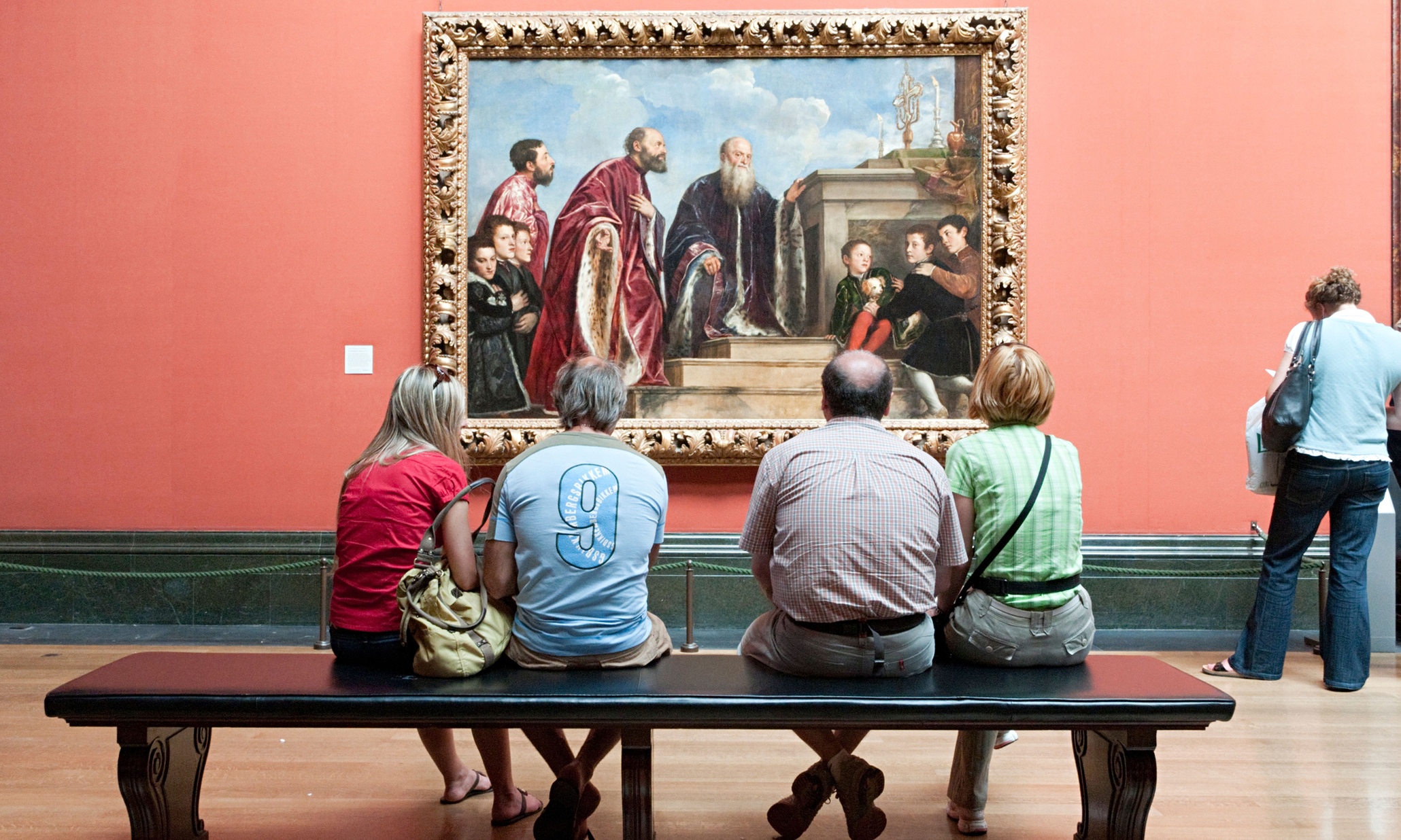 Человек рассматривает картину. Люди рассматривают картины в музее. Люди в художественной галерее. Картина на стене в музее. Любование картиной.